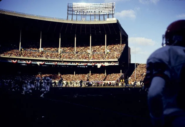 Cleveland Browns quarterback Bernie Kosar scrambles in the shadows at Cleveland Municipal Stadium in a 1986 playoff victory over the New York Jets. 