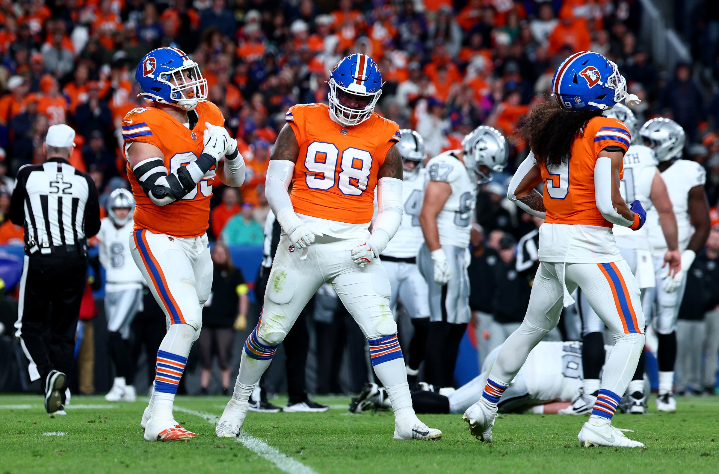 DENVER, COLORADO - NOVEMBER 06: Zach Allen #99, Talanoa Hufanga #9 and Malcolm Roach #97 of the Denver Broncos celebrate a sack against the Las Vegas Raiders during the second quarter in the game at Empower Field At Mile High on November 06, 2025 in Denver, Colorado. (Photo by Tyler Schank/Getty Images)