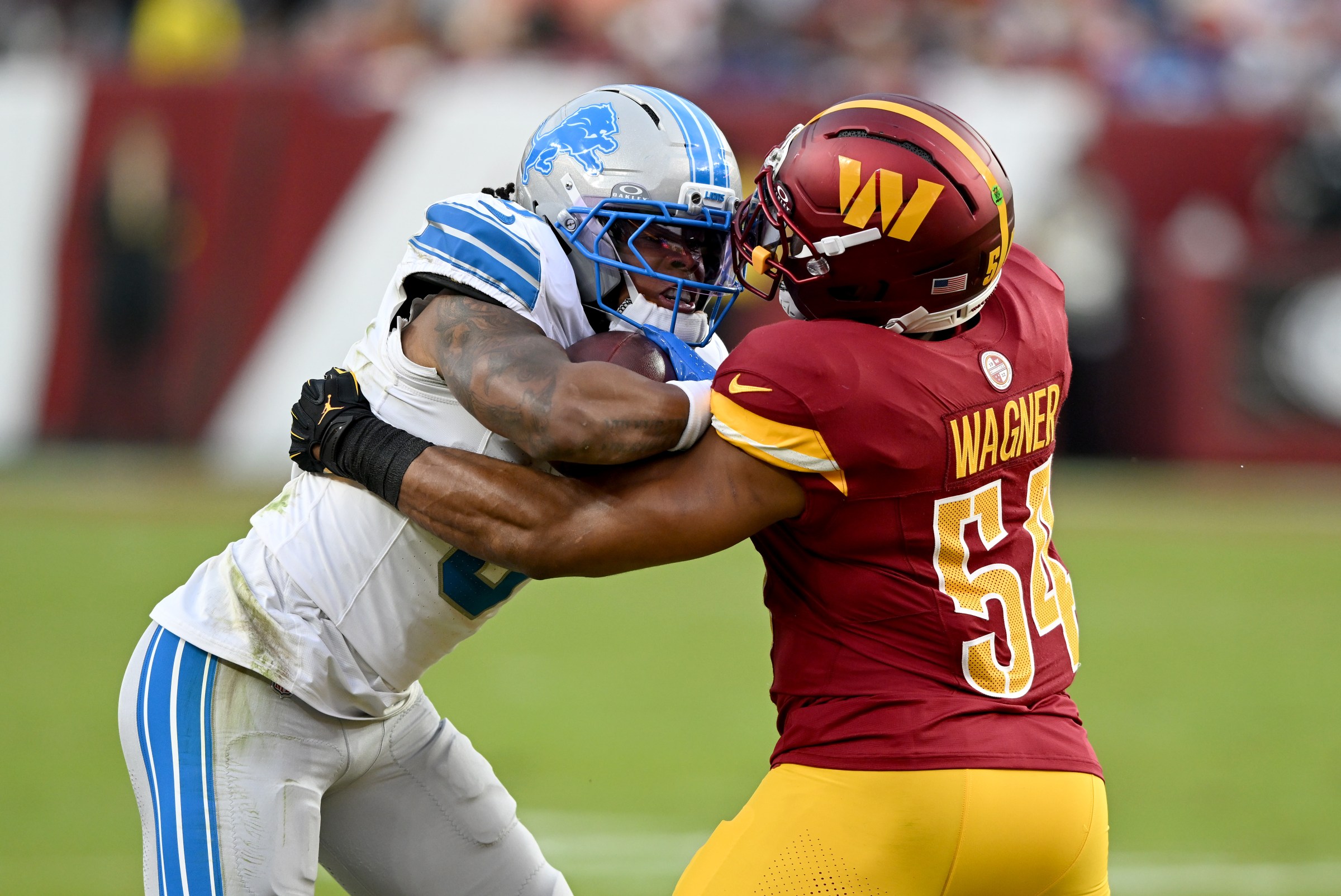 LANDOVER, MARYLAND - NOVEMBER 09: Jahmyr Gibbs #0 of the Detroit Lions is tackled by Bobby Wagner #54 of the Washington Commanders at Northwest Stadium on November 09, 2025 in Landover, Maryland. (Photo by G Fiume/Getty Images)