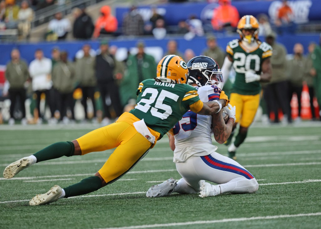 Green Bay Packers player (25) tackling New York Giants wide receiver Isaiah Hodgins (89) in the 4th quarter.