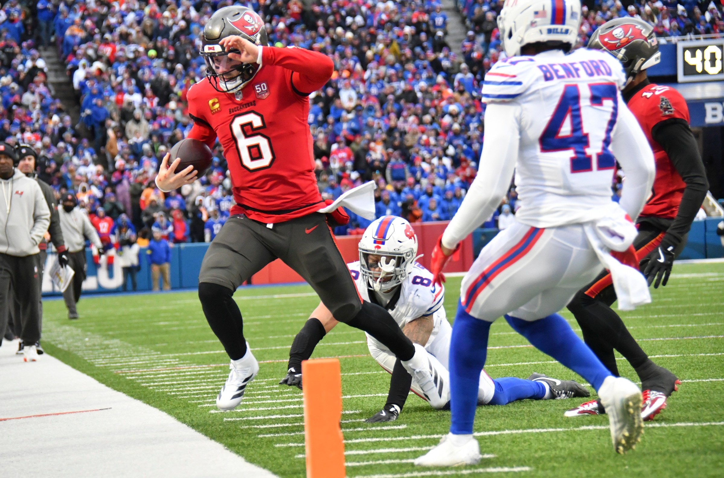 Nov 16, 2025; Orchard Park, New York, USA; Tampa Bay Buccaneers quarterback Baker Mayfield (6) runs out of bounds against Buffalo Bills linebacker Terrel Bernard (8) and cornerback Christian Benford (47) during the third quarter of the game at Highmark Stadium. Mandatory Credit: Mark Konezny-Imagn Images