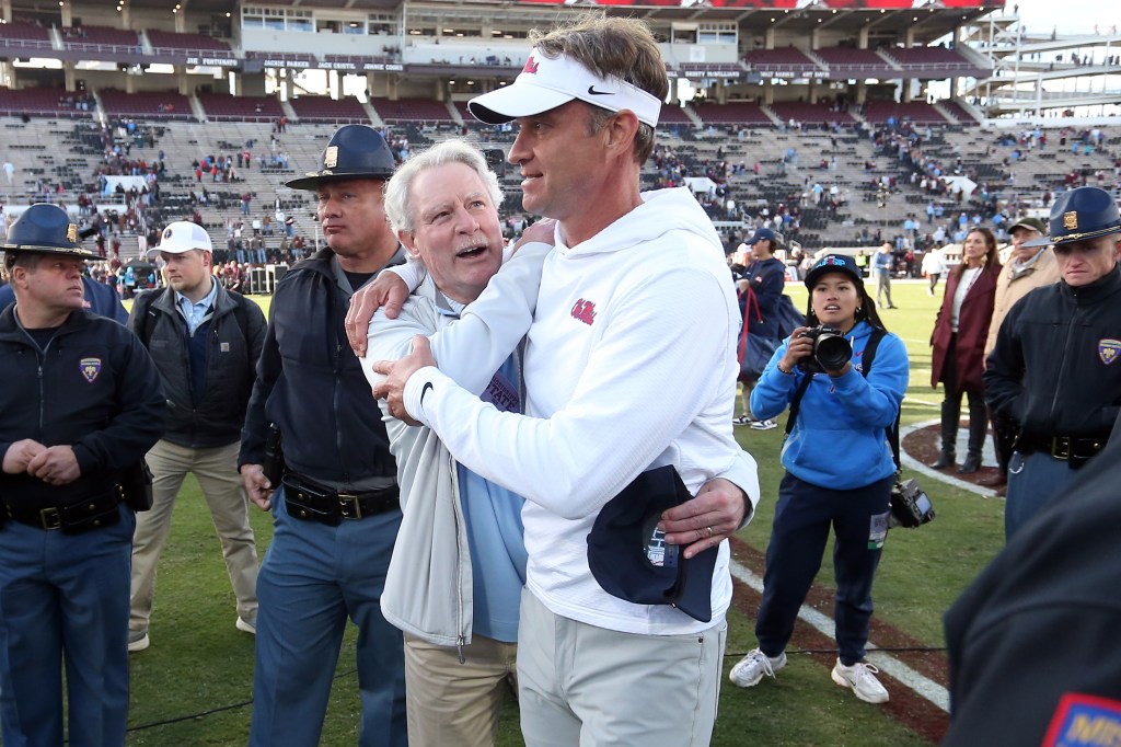 Mississippi Rebels head coach Lane Kiffin embraces chancellor Glenn Boyce after defeating the Mississippi State Bulldogs.