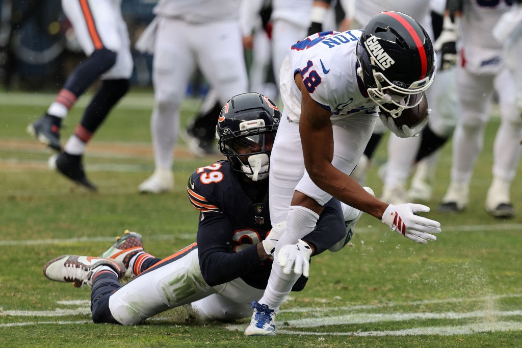 New York Giants wide receiver Darius Slayton (18) catches the ball as Chicago Bears cornerback Tyrique Stevenson (29) tackles him.