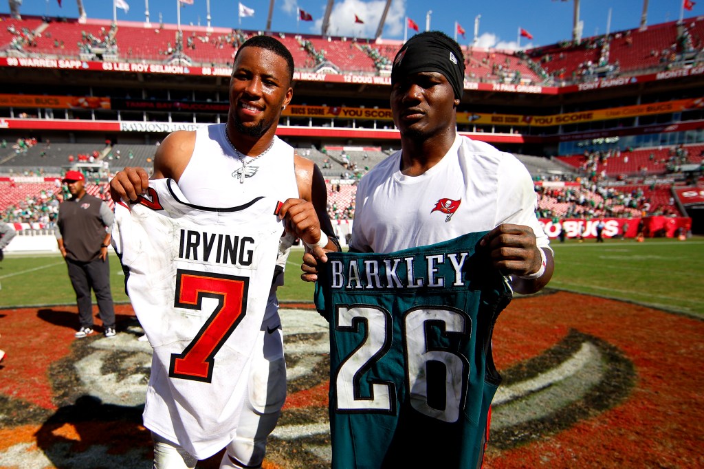 Saquon Barkley #26 of the Philadelphia Eagles and Bucky Irving #7 of the Tampa Bay Buccaneers exchange jerseys after the game at Raymond James Stadium on September 28, 2025 in Tampa, Florida.  