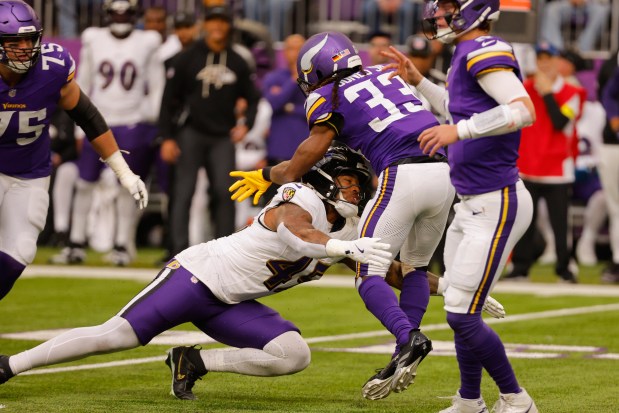 Baltimore Ravens linebacker Mike Green (45) tackles Minnesota Vikings running back Aaron Jones Sr. (33) in the first half of an NFL football game, Sunday, Nov. 9, 2025, in Minneapolis. (AP Photo/Bruce Kluckhohn)
