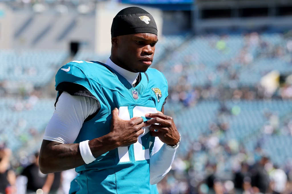 Travis Hunter in a teal Jacksonville Jaguars uniform warming up.