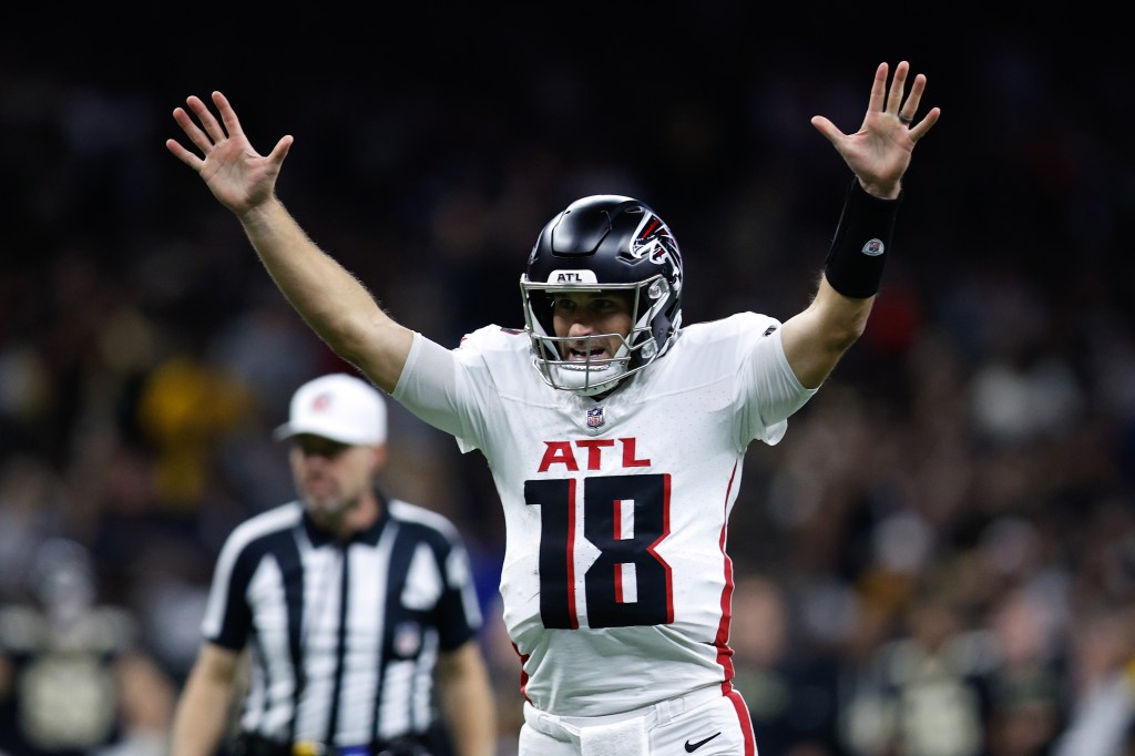 Atlanta Falcons player Kyle Pitts (18) with his hands raised during a game against the New Orleans Saints.