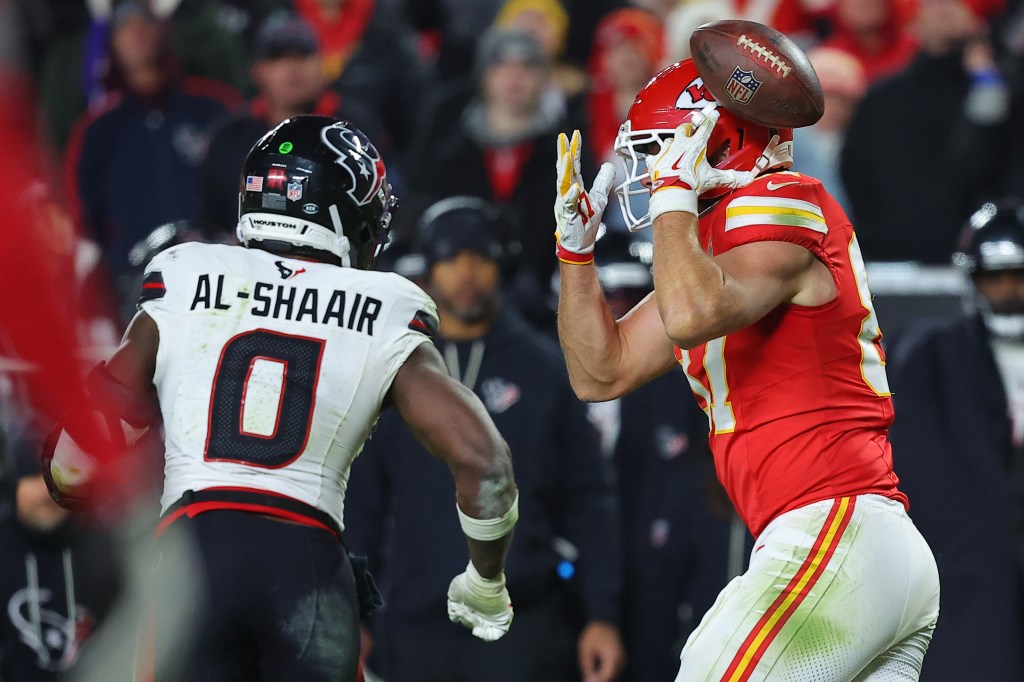 Azeez Al-Shaair of the Houston Texans intercepts a pass intended for Travis Kelce of the Kansas City Chiefs.