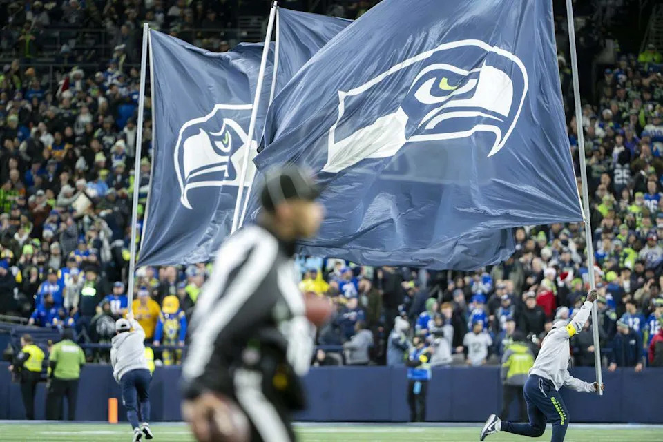 Seattle Seahawks flags are run across the field after a touchdown against the Los Angeles Rams at Lumen Field, on Thursday, Dec. 18, 2025, in Seattle.