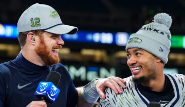 Sam Darnold of the Seattle Seahawks laughs with Jaxon Smith-Njigba