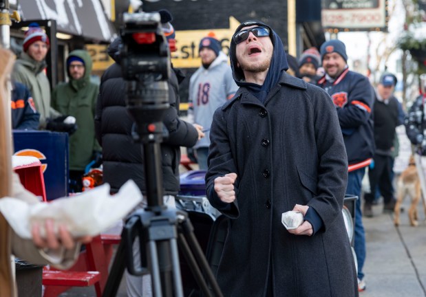 Bears fans cheer while lining up for free hot dogs, Dec. 2, 2025, at The Wieners Circle in Chicago's Lincoln Park neighborhood. (Brian Cassella/Chicago Tribune)