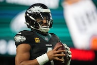 Philadelphia Eagles' Jalen Hurts warms up during an NFL football game against the Chicago...