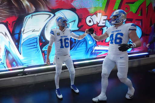Detroit Lions quarterback Jared Goff (16) and linebacker Jack Campbell bump fists prior to an NFL football game against the Dallas Cowboys Thursday, Dec. 4, 2025, in Detroit. (AP Photo/Paul Sancya)