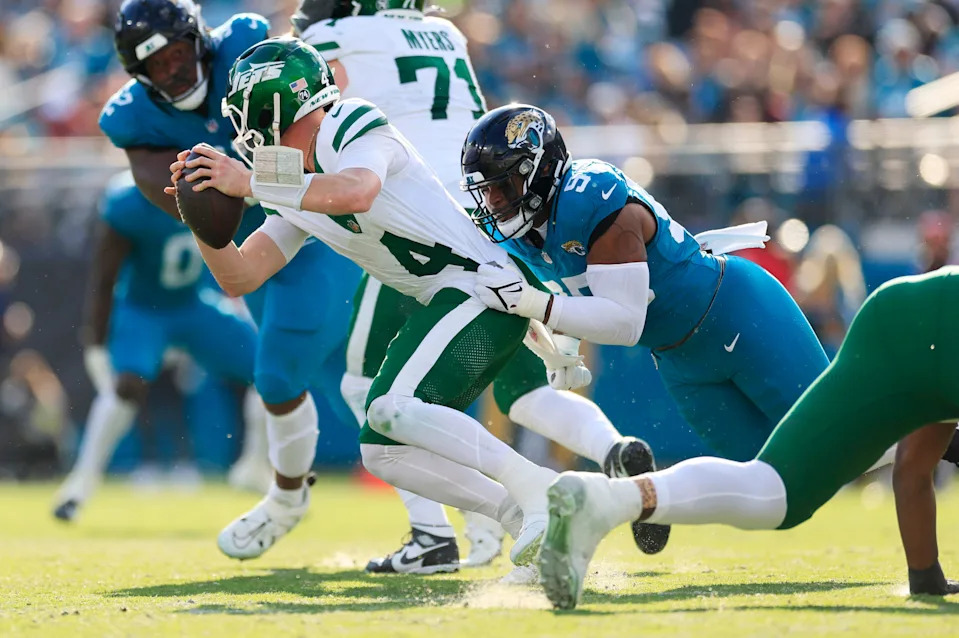 New York Jets quarterback Brady Cook (4) is sacked by Jacksonville Jaguars defensive end BJ Green II (95) during the third quarter of a NFL football matchup at EverBank Stadium, Sunday, Dec. 14, 2025, in Jacksonville, Fla. The Jaguars defeated the Jets 48-20. [Corey Perrine/Florida Times-Union]