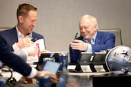Dallas Cowboys owner Jerry Jones hands the phone back to his son Jerry Jr. (not pictured) as...