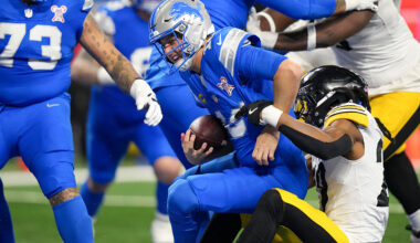 Jared Goff #16 of the Detroit Lions speaks with line judge Daniel Gallagher #85 during the second half of an NFL football game against the Pittsburgh Steelers at Ford Field on December 21, 2025 in Detroit, Michigan. 