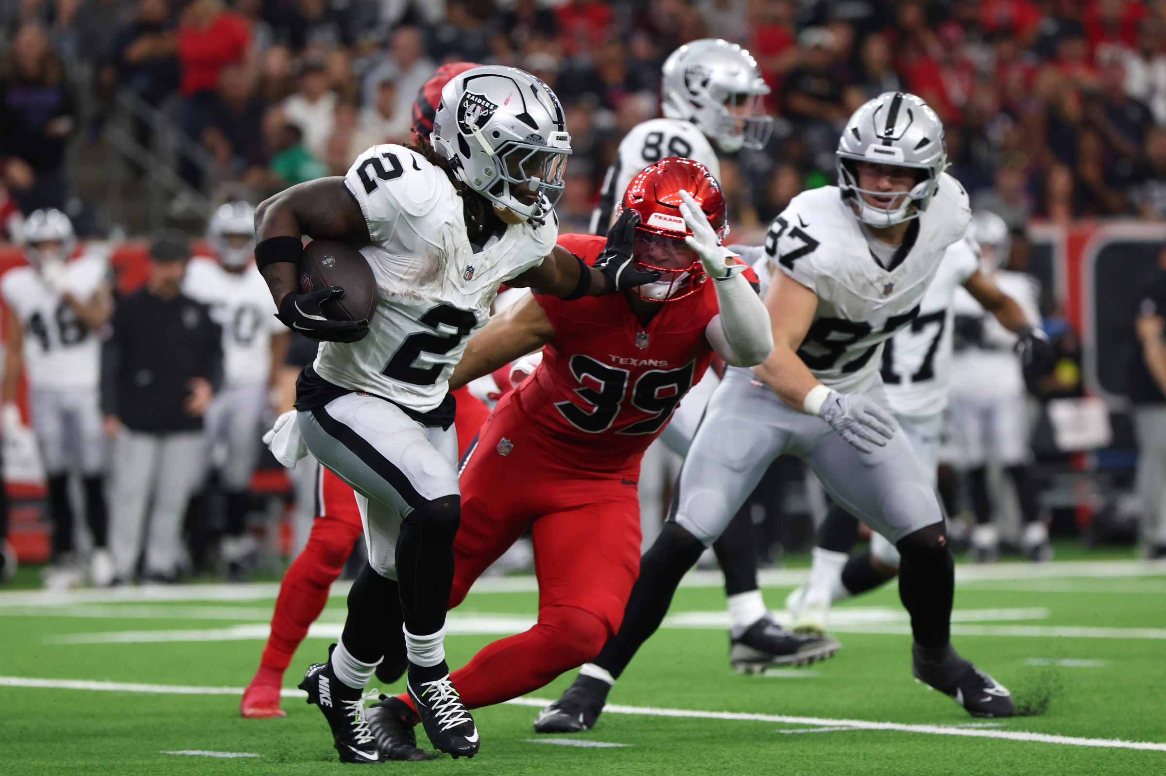 HOUSTON, TEXAS - DECEMBER 21: Ashton Jeanty #2 of the Las Vegas Raiders stiff arms Henry To’Oto’O #39 of the Houston Texans during the second quarter at NRG Stadium on December 21, 2025 in Houston, Texas. (Photo by Tim Warner/Getty Images)