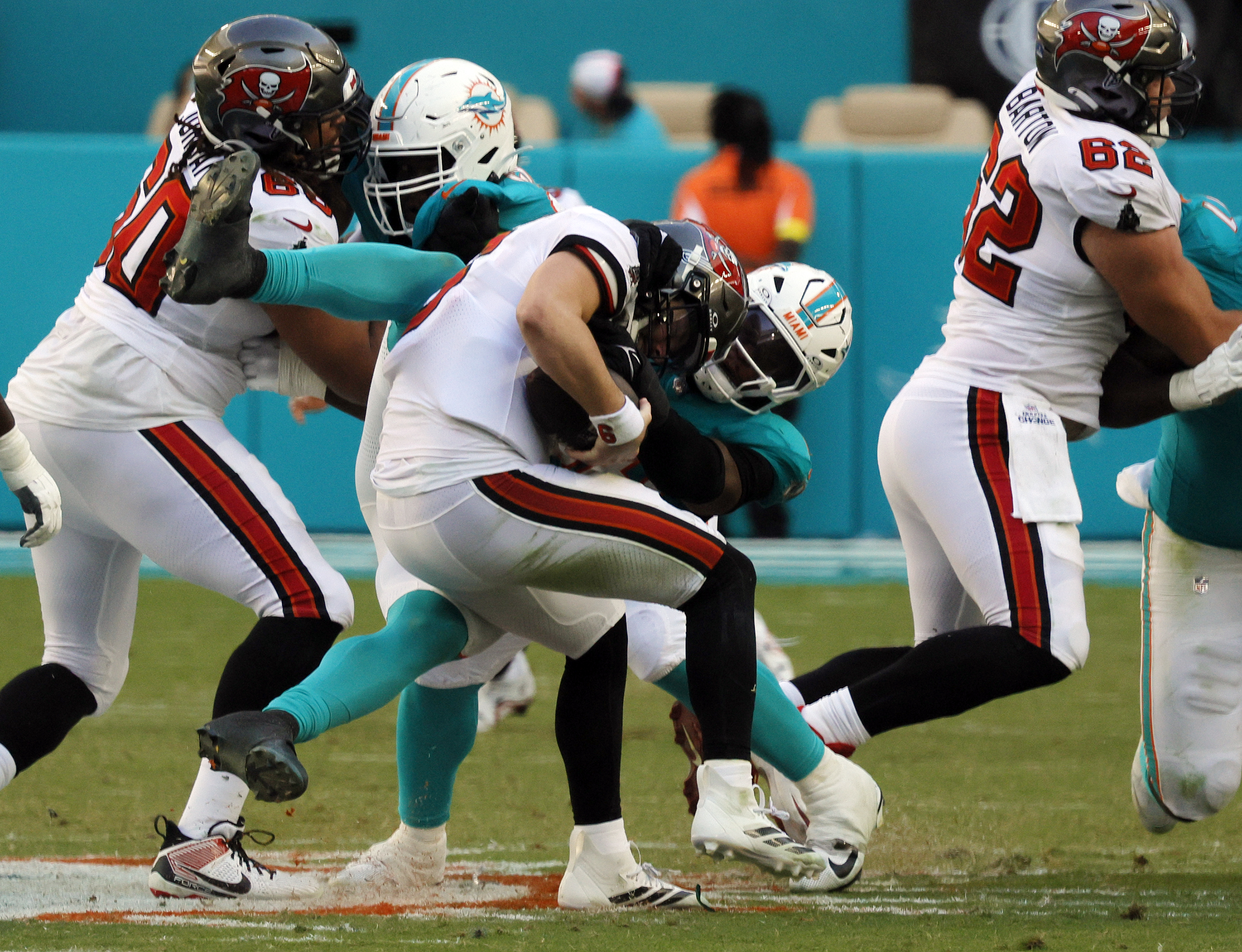 Miami Dolphins linebacker Quinton Bell (56) grabs but cannot bring...