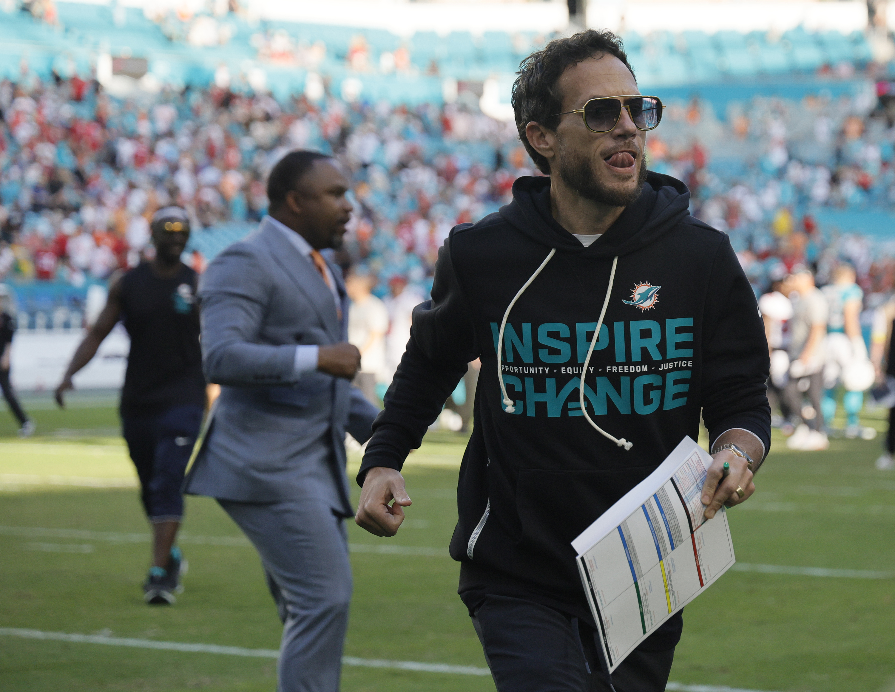 Miami Dolphins head coach Mike McDaniel runs off the field...