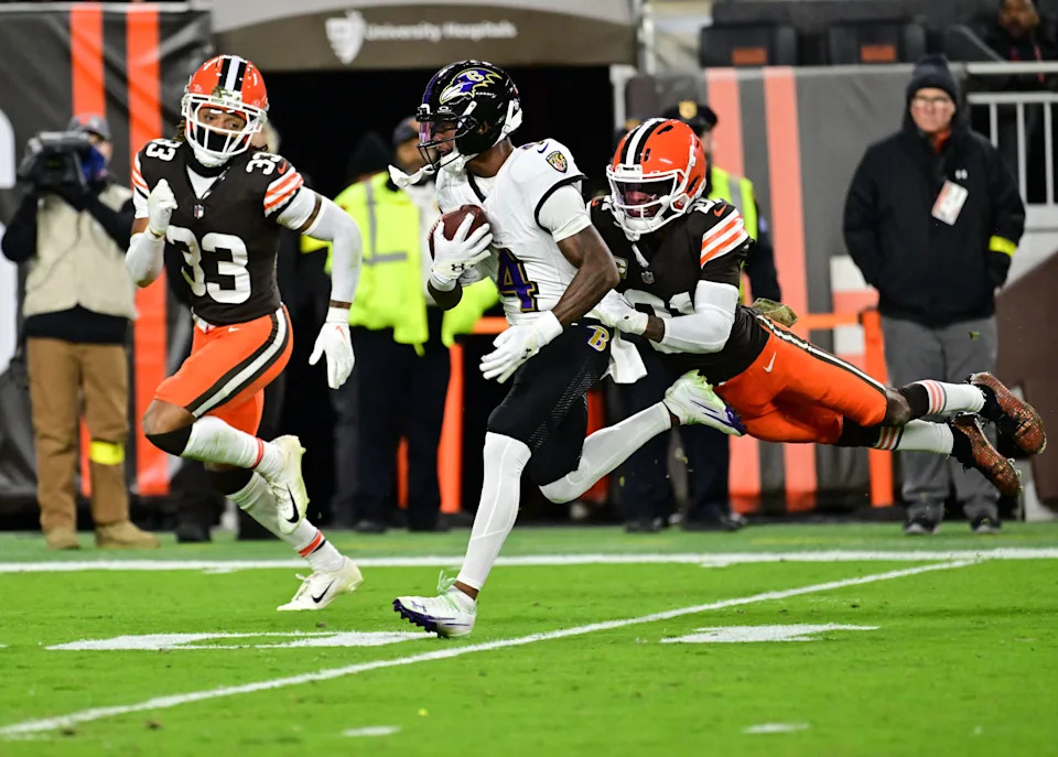 Baltimore Ravens wide receiver Zay Flowers attempts to avoid a tackle by Cleveland Browns cornerback Denzel Ward.
