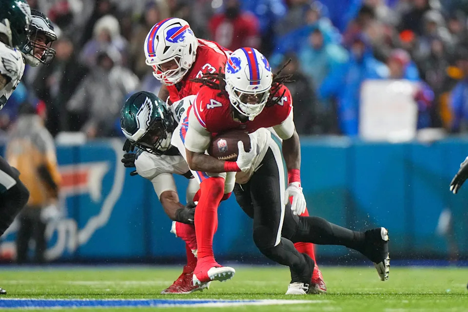 Dec 28, 2025; Orchard Park, New York, USA; Buffalo Bills running back James Cook III (4) runs the ball against Philadelphia Eagles linebacker Jalyx Hunt (58) during the second quarter at Highmark Stadium. Mandatory Credit: Gregory Fisher-Imagn Images