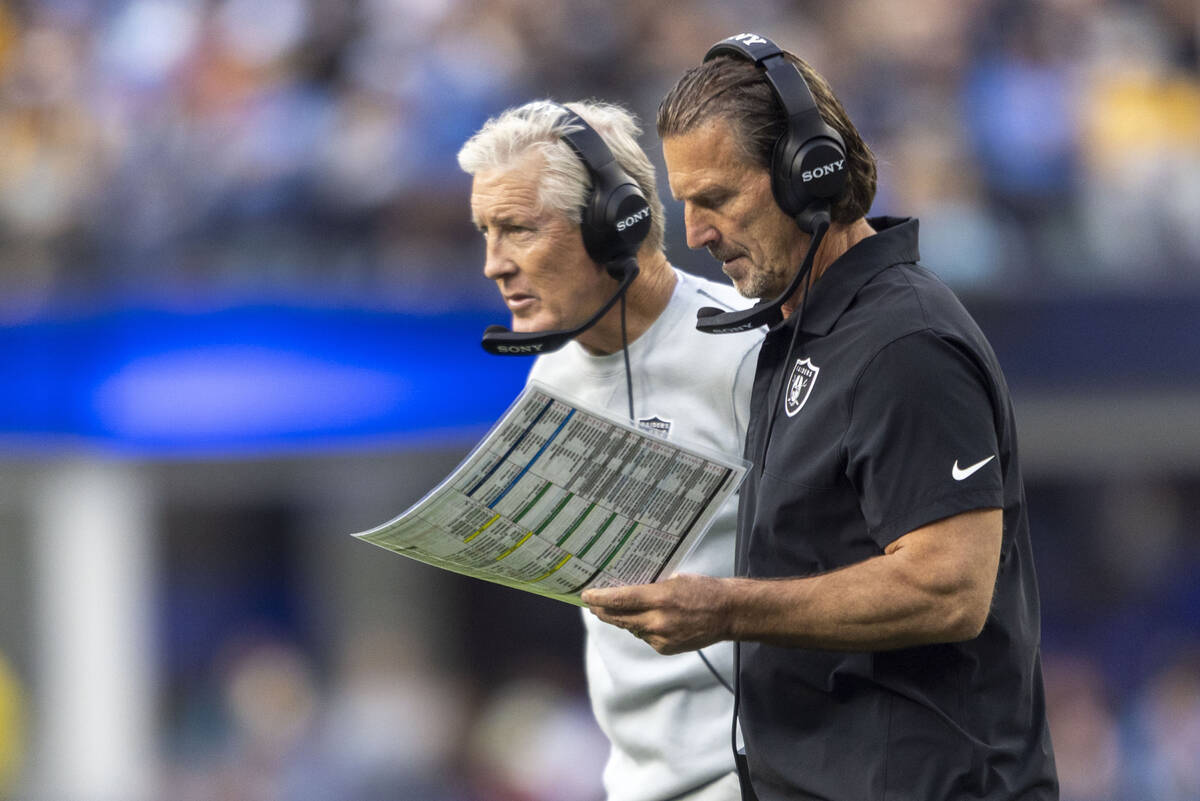 Raiders interim offensive coordinator Greg Olson, right, draws up a play while Raiders head coa ...