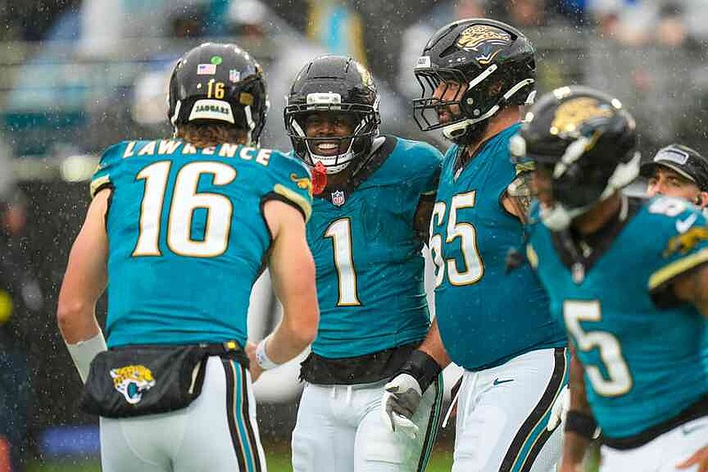 Jacksonville Jaguars running back Travis Etienne Jr. (1) celebrates a touchdown with quarterback Trevor Lawrence (16) during the first half of an NFL football game against the Indianapolis Colts, Sunday, Dec. 7, 2025, in Jacksonville, Fla. (AP Photo/John Raoux)