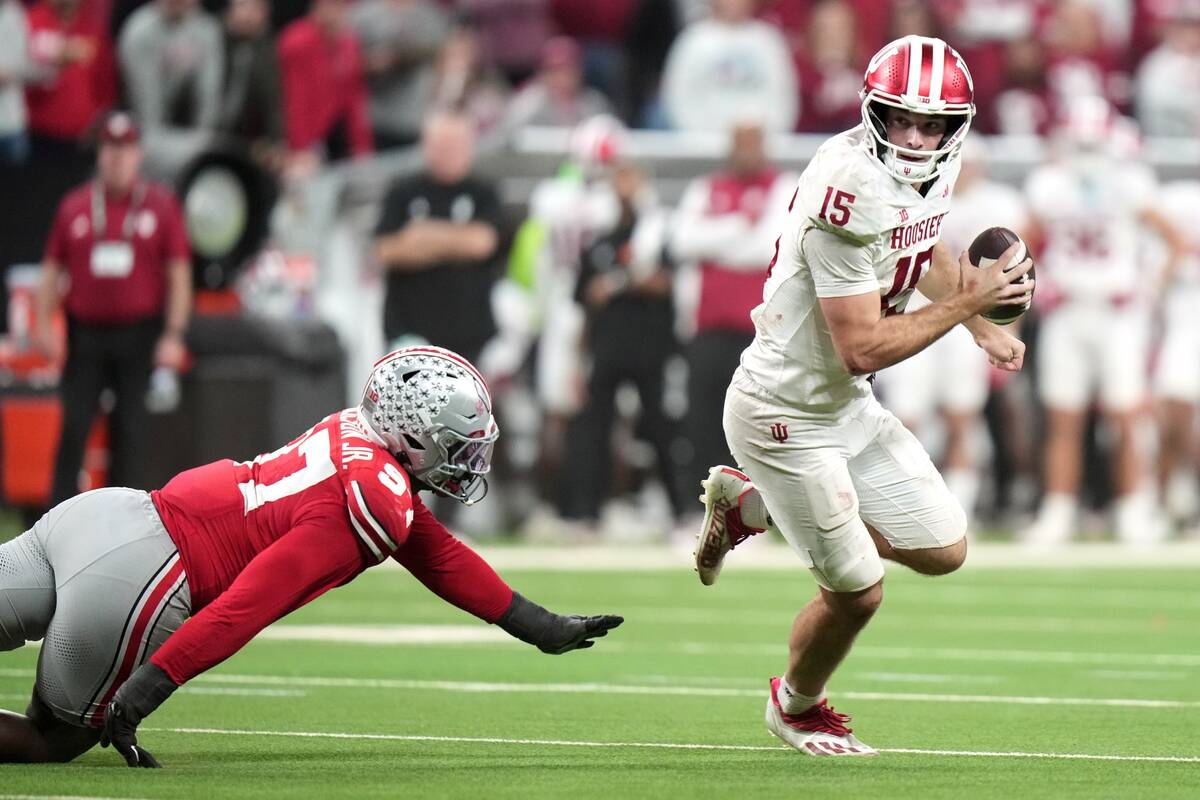 Indiana's Fernando Mendoza scrambles pasr Ohio State's Kenyatta Jackson Jr. during th ...