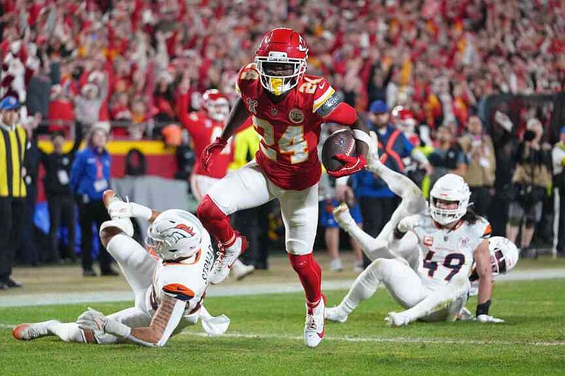 Kansas City Chiefs running back Brashard Smith, center, evades tackles by Denver Broncos linebacker Justin Strnad, left, and linebacker Alex Singleton (49) while scoring a touchdown during the first half of an NFL football game Thursday, Dec. 25, 2025, in Kansas City, Mo. (AP Photo/Ed Zurga)