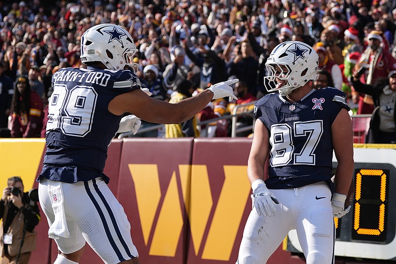 Dallas Cowboys tight end Jake Ferguson (87) is congratulated by teammate defensive tackle Perrion Winfrey (99) after catching a touchdown pass during the first half an NFL football game against the Washington Commanders Thursday, Dec. 25, 2025, in Landover, Md. (AP Photo/Stephanie Scarbrough)