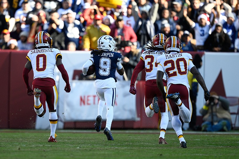 Dallas Cowboys wide receiver Kavontae Turpin (9) heads for the end zone to score on a touchdown pass as Washington Commanders cornerback Mike Sainristil (0), cornerback Antonio Hamilton Sr., and safety Quan Martin (20) give chase during the first half an NFL football game Thursday, Dec. 25, 2025, in Landover, Md. (AP Photo/Nick Wass)