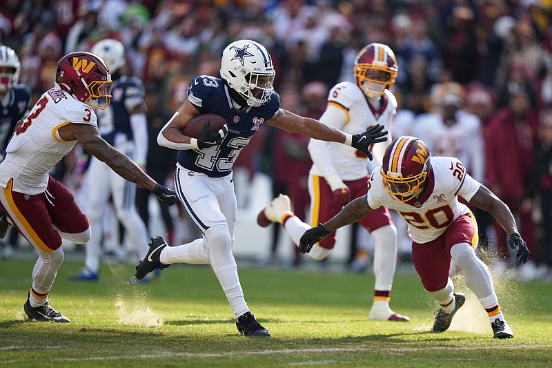 Dallas Cowboys running back Malik Davis (43) runs with the ball as Washington Commanders safety Quan Martin (20) and safety Will Harris (3) defend during the first half an NFL football game Thursday, Dec. 25, 2025, in Landover, Md. (AP Photo/Stephanie Scarbrough)