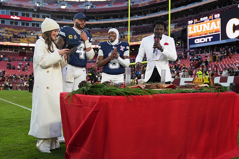 Dallas Cowboys quarterback Dak Prescott (4) and wide receiver Kavontae Turpin (9) are interview by Kay Adams, left, and Michael Irvin, right, following an NFL football game against the Washington Commanders Thursday, Dec. 25, 2025, in Landover, Md. (AP Photo/Stephanie Scarbrough)