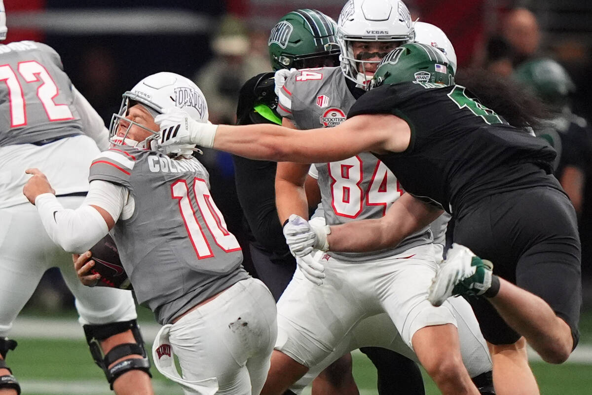 UNLV quarterback Anthony Colandrea (10) is grabbed by Ohio defensive lineman Evan Herrmann (11) ...