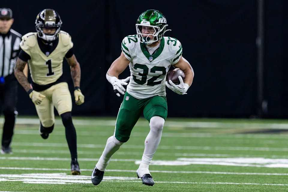 Dec 21, 2025; New Orleans, Louisiana, USA; New York Jets running back Isaiah Davis (32) runs against New Orleans Saints cornerback Alontae Taylor (1) during the second half at Caesars Superdome. Mandatory Credit: Stephen Lew-Imagn Images