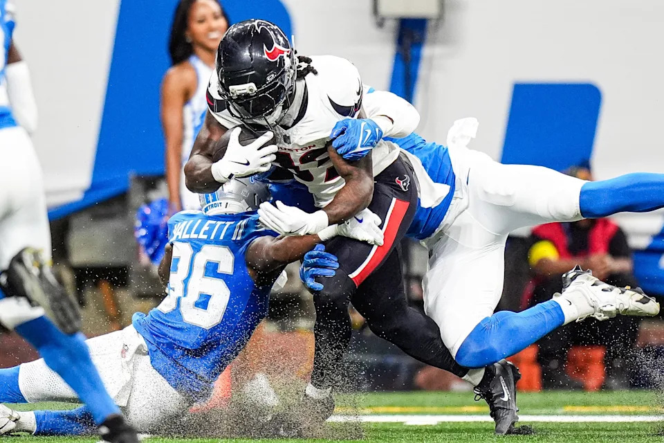 Houston Texans running back Dare Ogunbowale (33) makes a catch against Detroit Lions safety Erick Hallett (36) and linebacker Mitchell Agude (50) during the first half at Ford Field in Detroit on Saturday, August 23, 2025.