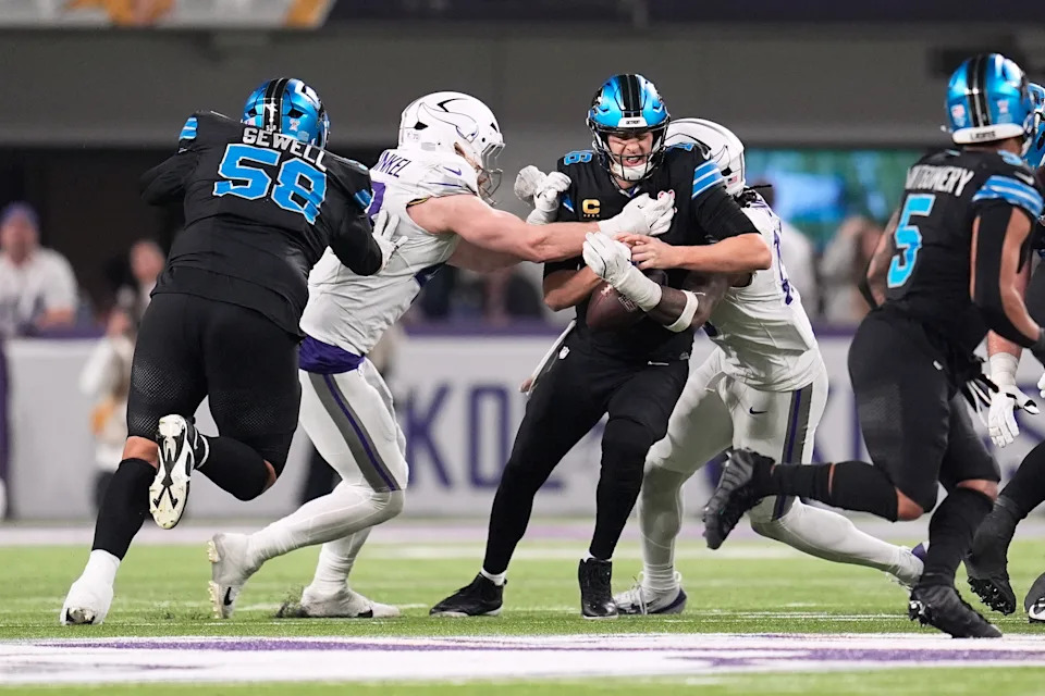 Detroit Lions quarterback Jared Goff, center, is sacked by Minnesota Vikings linebackers Andrew van Ginkel, second from left, and Dallas Turner, right, during the second half of an NFL football game, Thursday, Dec. 25, 2025, in Minneapolis. (AP Photo/Abbie Parr)