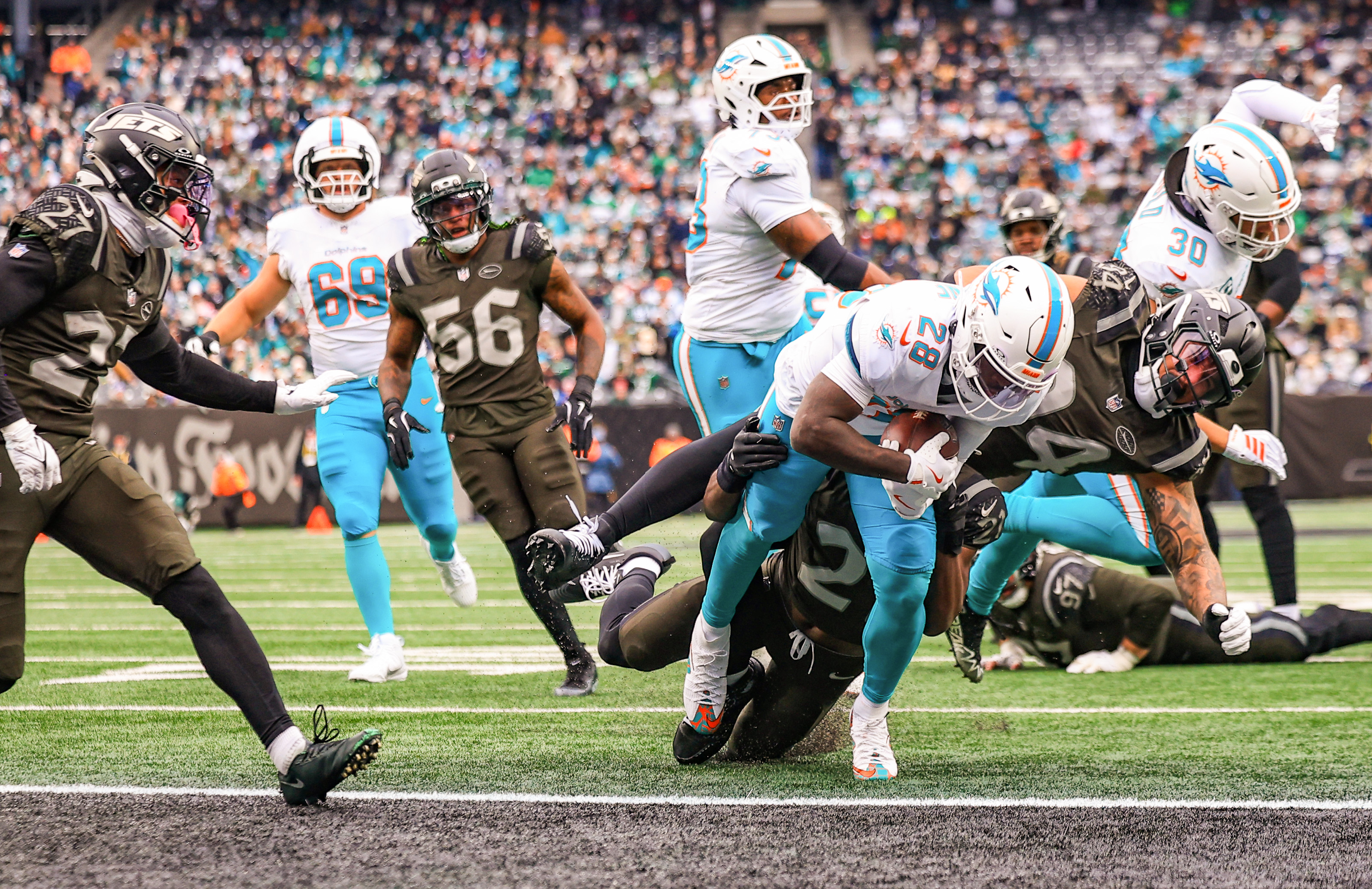 New York Jets defensive end Tyler Baron (94) and cornerback Brandon Stephens (21) can’t prevent Miami Dolphins running back De'Von Achane (28) from scoring a rushing touchdown during the first half, Sunday, Dec. 7, 2025 at MetLife Stadium in East Rutherford, N.J.