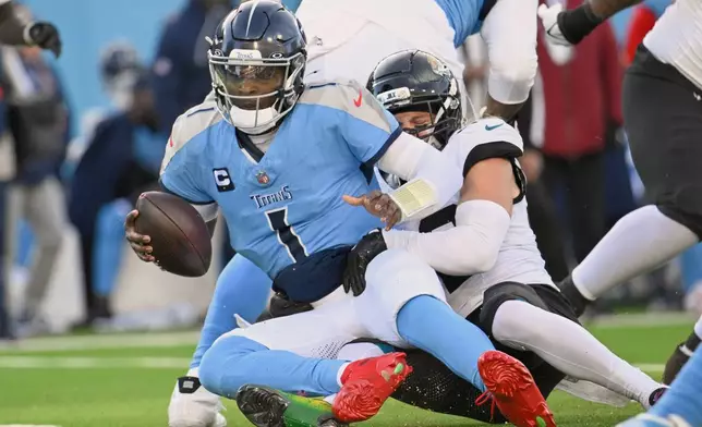 Tennessee Titans quarterback Cam Ward (1) is sacked by Jacksonville Jaguars safety Andrew Wingard during the second half of an NFL football game Sunday, Nov. 30, 2025, in Nashville, Tenn. (AP Photo/John Amis)