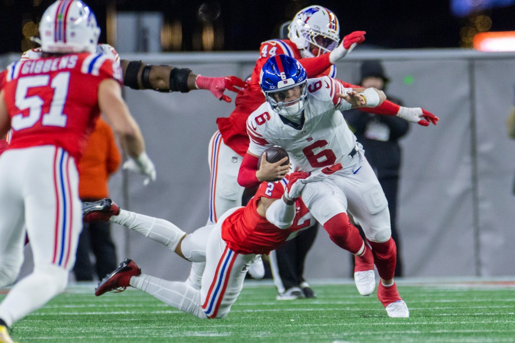 New York Giants quarterback Jaxson Dart forced out of the pocket by New England Patriots linebacker Harold Landry III.