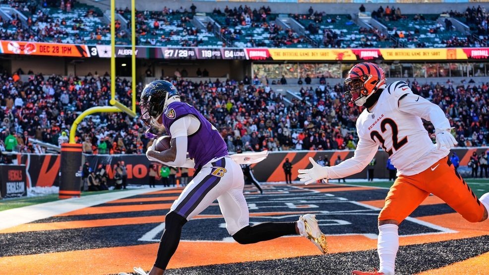 Baltimore Ravens wide receiver Zay Flowers, left, makes a catch for a touchdown past Cincinnati Bengals safety Geno Stone (22) during the first half of an NFL football game, Sunday, Dec. 14, 2025, in Cincinnati. (AP Photo/Carolyn Kaster)
