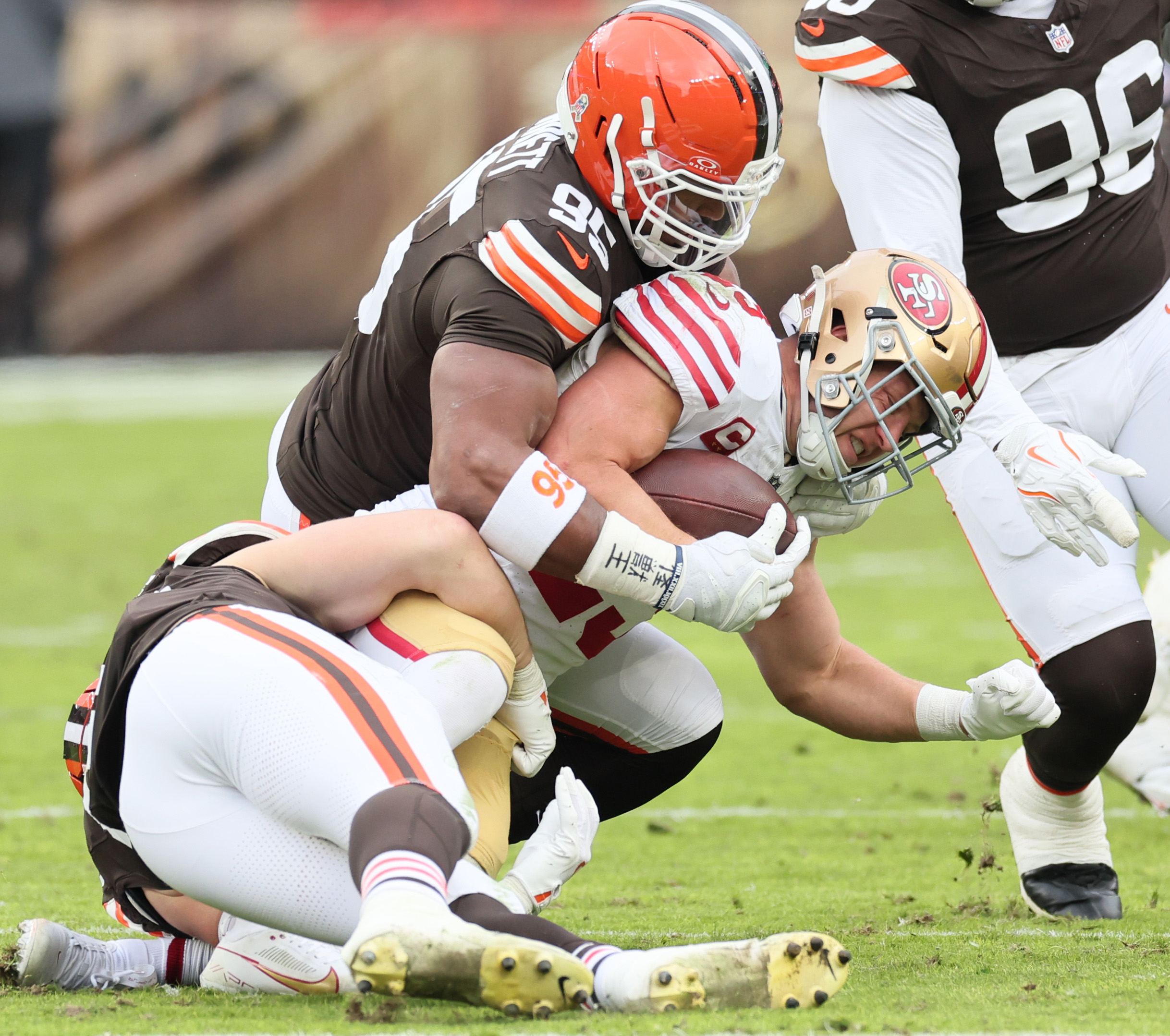 Cleveland Browns defensive end Myles Garrett (top) and Cleveland Browns linebacker Carson Schwesinger team up to tackle San Francisco 49ers running back Christian McCaffrey on a rush in the first half at Huntington Bank Field.