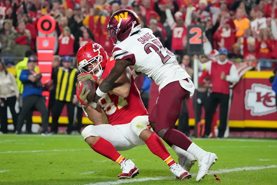 Oct 27, 2025; Kansas City, Missouri, USA; Kansas City Chiefs tight end Travis Kelce (87) makes a reception for a touchdown defended by Washington Commanders safety Darnell Savage (25) during the third quarter of the game at GEHA Field at Arrowhead Stadium. Mandatory Credit: Denny Medley-Imagn Images