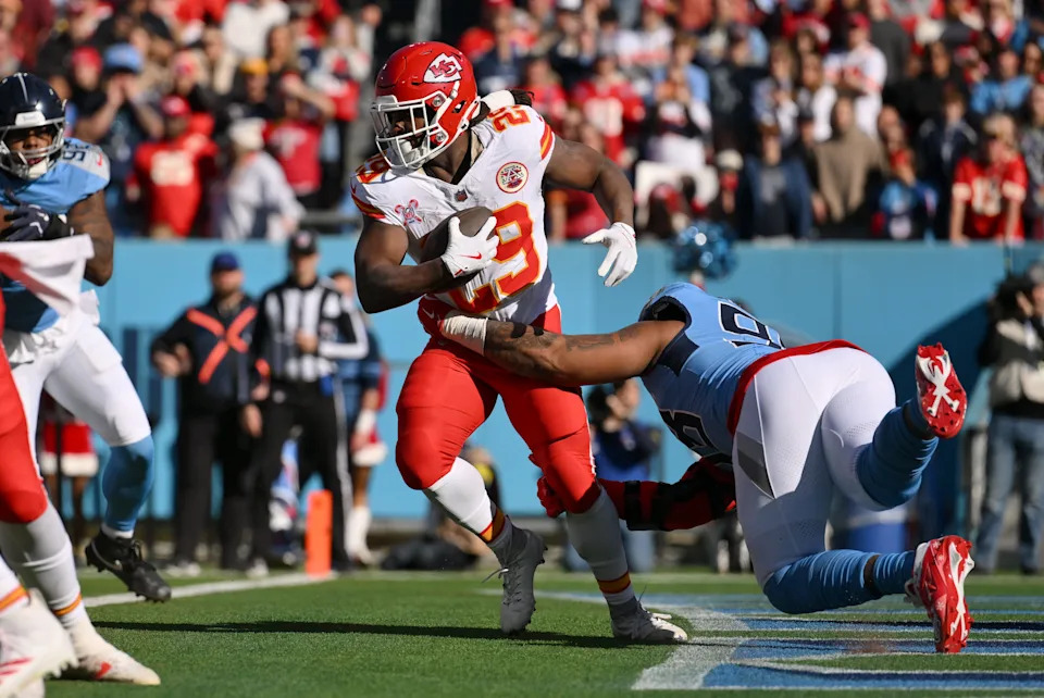 Dec 21, 2025; Nashville, Tennessee, USA; Kansas City Chiefs running back Kareem Hunt (29) runs against Tennessee Titans defensive tackle Jeffery Simmons (98) during the first half at Nissan Stadium. Mandatory Credit: Steve Roberts-Imagn Images