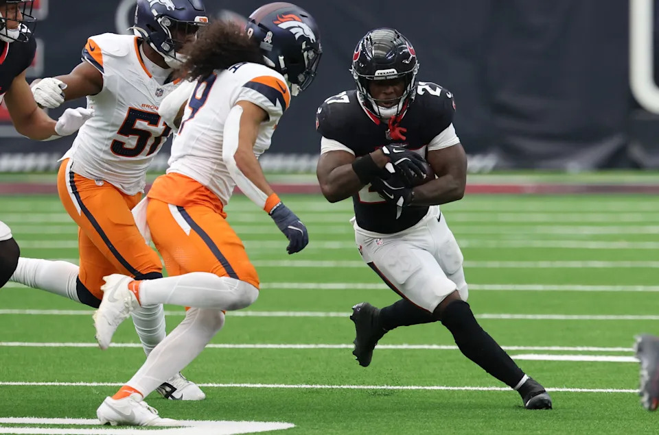 Nov 2, 2025; Houston, Texas, USA; Houston Texans running back Woody Marks (27) runs against Denver Broncos linebacker Que Robinson (51) and safety Talanoa Hufanga (9) during the second half at NRG Stadium. Mandatory Credit: Thomas Shea-Imagn Images