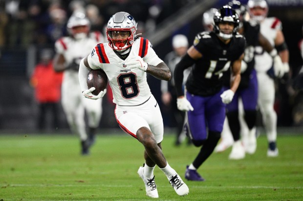New England Patriots wide receiver Stefon Diggs runs in front of Baltimore Ravens safety Kyle Hamilton (14) during the first half of an NFL game Sunday. (AP Photo/Nick Wass)