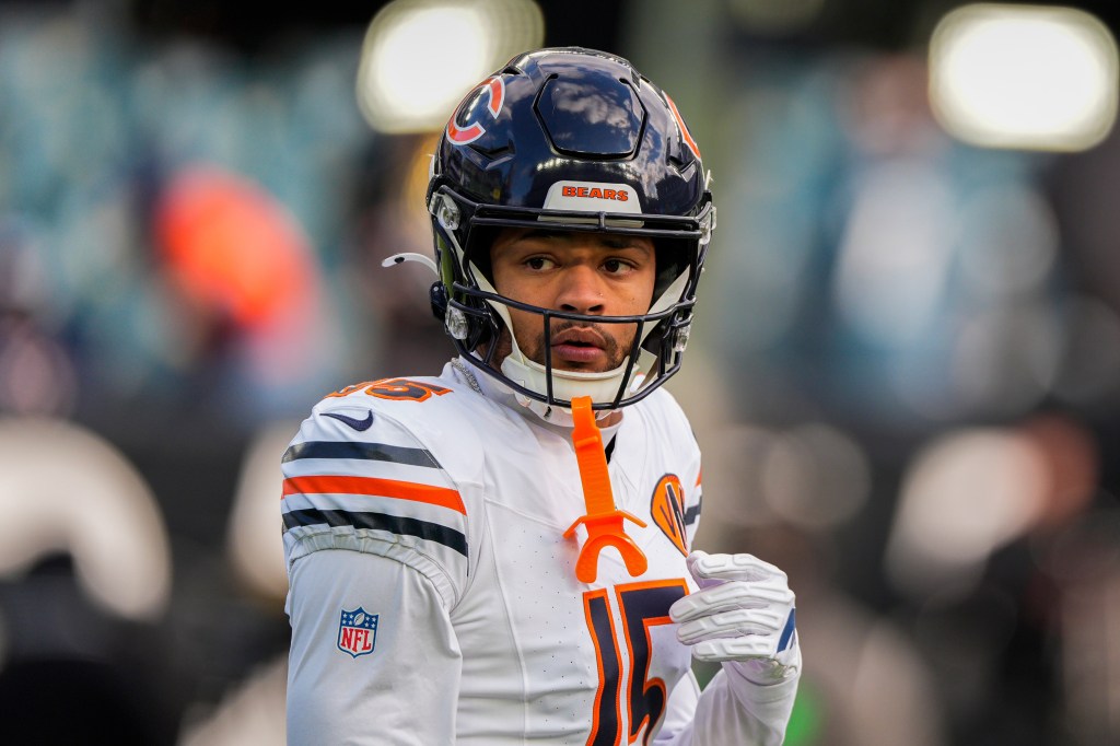 Rome Odunze, a Chicago Bears player, wearing a white jersey with orange and navy stripes on the shoulders, and a navy helmet.