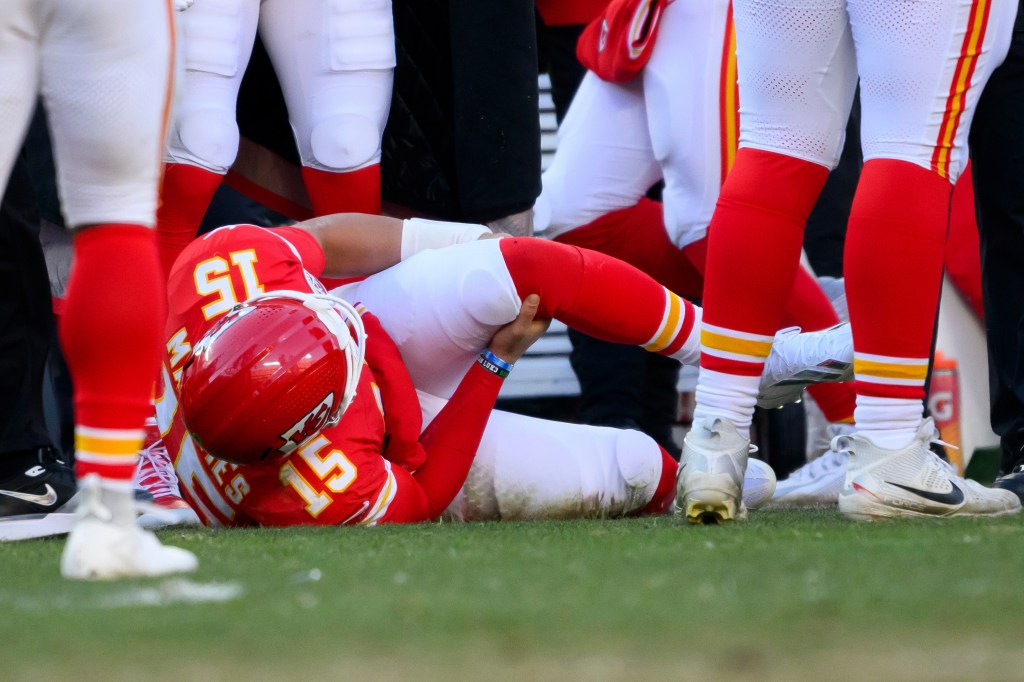 Kansas City Chiefs quarterback Patrick Mahomes grabs his knee after being injured during the second half of an NFL football game against the Los Angeles Chargers, Sunday, Dec. 14, 2025 in Kansas City, Mo. 