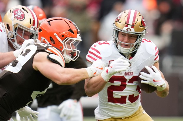 San Francisco 49ers running back Christian McCaffrey (23) runs against Cleveland Browns linebacker Carson Schwesinger during the first half of an NFL football game, Sunday, Nov. 30, 2025, in Cleveland. (AP Photo/Sue Ogrocki)