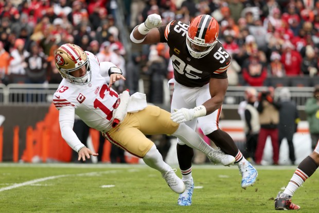 San Francisco 49ers quarterback Brock Purdy (13) is knocked down by Cleveland Browns defensive end Myles Garrett (95) during an NFL football game, Sunday, Nov. 30 2025, in Cleveland. (AP Photo/Kirk Irwin)